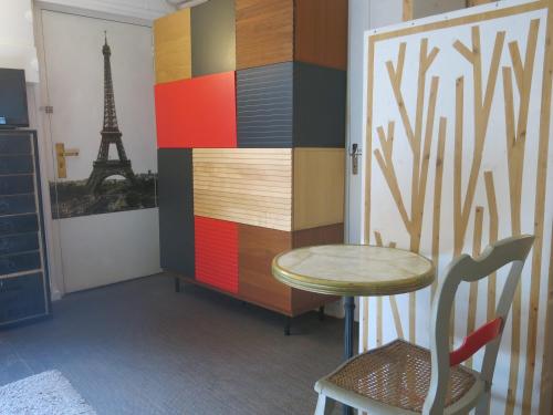 une table et une chaise dans une pièce avec la tour Eiffel dans l'établissement Studio Bièvre St Germain CityCosy, à Paris