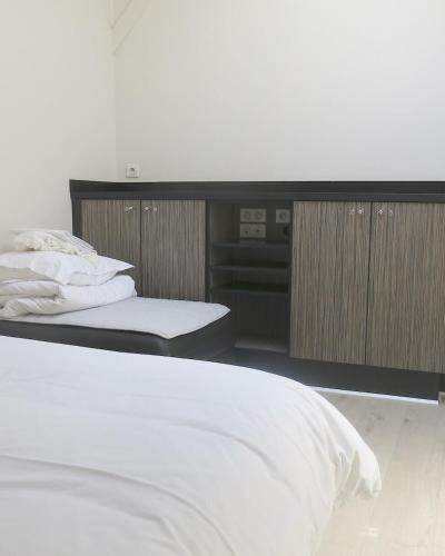 une chambre avec deux lits et un bureau avec avertisement dans l'établissement Mini Loft Daval, à Paris