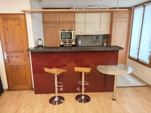 - une cuisine avec un comptoir, 2 chaises et une table dans l'établissement Appartement Faubourg Montmartre CityCosy, à Paris