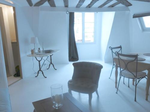 un salon blanc avec une table et des chaises dans l'établissement Apartment Saintonge CityCosy, à Paris