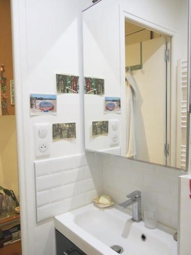 une salle de bain blanche avec un lavabo et un miroir dans l'établissement Appt Letort CityCosy, à Paris