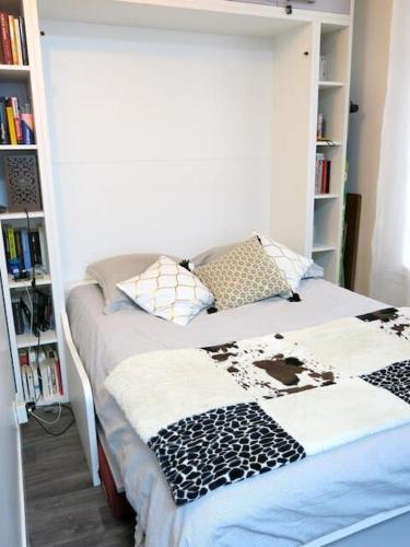 - un lit dans une chambre avec une étagère dans l'établissement Charme Belfort CityCosy, à Vincennes