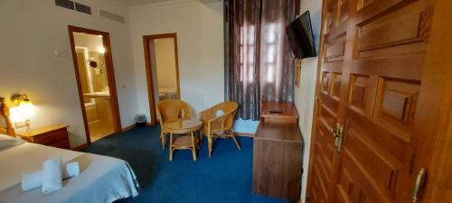 ein Hotelzimmer mit einem Bett, einem Tisch und Stühlen in der Unterkunft Hotel Mairena in Mairena del Alcor