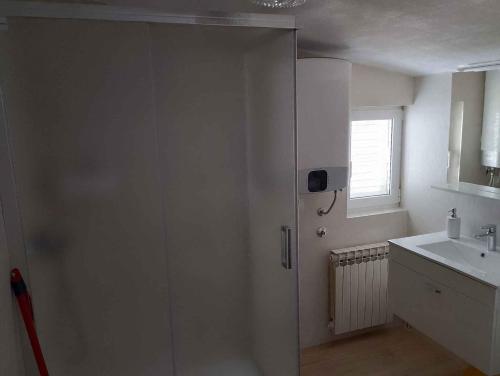 bagno bianco con doccia e lavandino di Apartment in Zadar/Zadar Riviera 8183 a Smirić