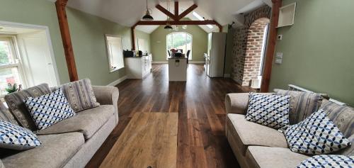a living room with two couches and wooden floors at The Haggard Self Catering Accommodation in Castleblayney