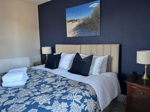 a bedroom with a bed with a blue wall at Glen Lyon Lodge Bed and Breakfast in Nairn
