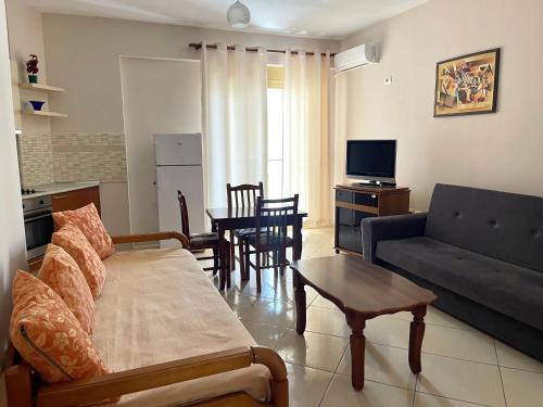 sala de estar con sofá y mesa en Deni Apartment, en Vlorë