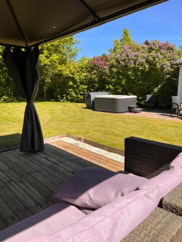 a bed on a wooden deck in a yard at Jonas Hus - Munkgaard in Store Heddinge