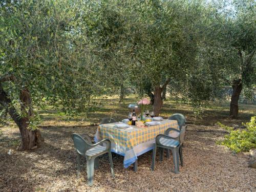 a table and chairs sitting under a tree at Apartment Casa ai Campi-1 by Interhome in Imperia