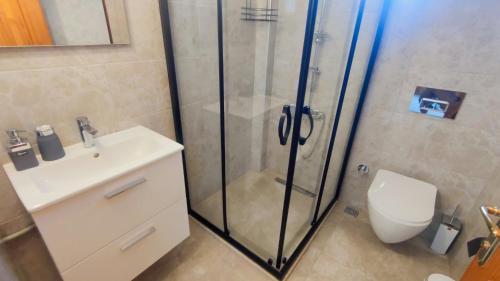 a bathroom with a shower and a toilet and a sink at Villa Günbatımı in Kaş