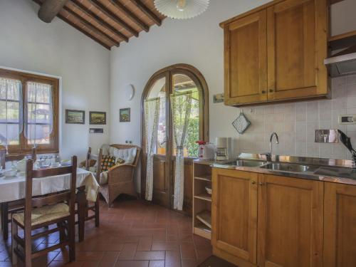 a kitchen with wooden cabinets and a table at Holiday Home Le Masse-1 by Interhome in Castelfranco Piandisco