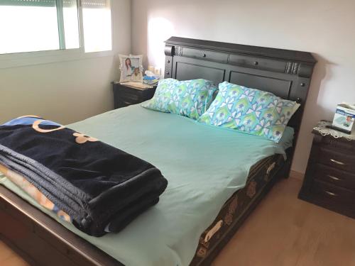 - une chambre avec un lit doté d'une tête de lit et d'oreillers noirs dans l'établissement One bedroom apartement at Rabat, à Rabat