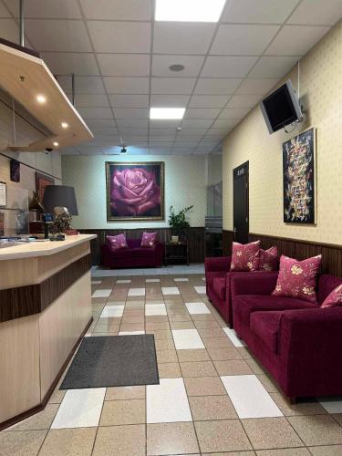 a lobby with two purple couches in a room at Via Baltica in Sargėnai