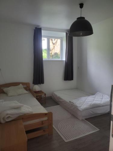 1 Schlafzimmer mit 2 Betten und einem Fenster in der Unterkunft Maison au calme Plessala Le Mené in Saint-Udy