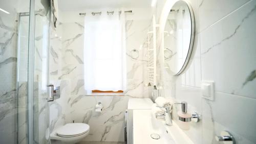 W łazience znajduje się toaleta, umywalka i lustro. w obiekcie Apartamenty EverySky - Myśliwska w mieście Karpacz