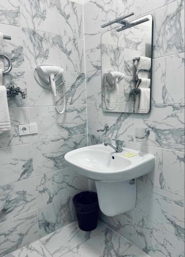 a white bathroom with a sink and a mirror at Via Baltica in Sargėnai