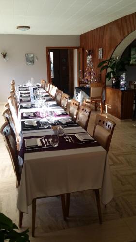 a long dining room with a long table and chairs at Hôtel Flor'Alpes in La Giettaz