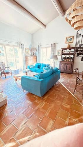 un grand salon avec des canapés bleus dans l'établissement Villa avec piscine dans le Luberon, à Ménerbes
