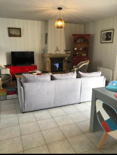 un salon avec un canapé et une cheminée dans l'établissement Maison à 400m de la plage, à Rivedoux-Plage