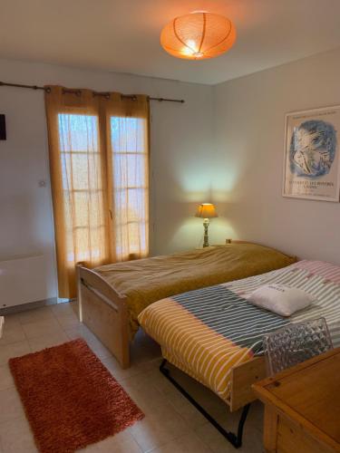 une chambre avec deux lits et une lampe et une fenêtre dans l'établissement Maison à 400m de la plage, à Rivedoux-Plage