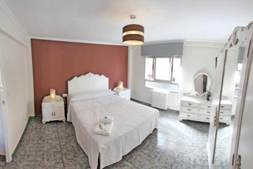 1 dormitorio con cama blanca y espejo en 3 bedrooms apartement with city view balcony and wifi at Villena, en Villena