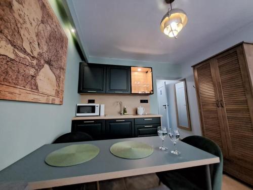 a kitchen with a table with wine glasses on it at DK Apartamenty Hotelove in Giżycko