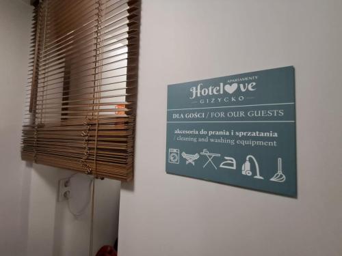 a sign on a wall next to a window at DK Apartamenty Hotelove in Giżycko