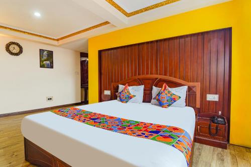 a bedroom with two beds and a wooden wall at FabHotel Roshan Residency Naidupuram in Kodaikānāl