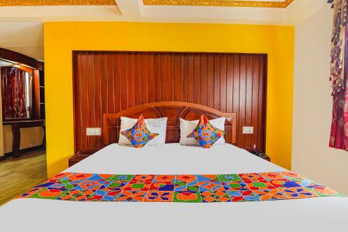 um quarto com uma cama grande e uma cabeceira em madeira em FabHotel Roshan Residency Naidupuram em Kodaikanal