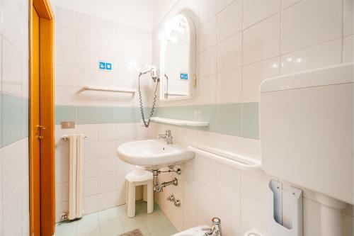 W białej łazience znajduje się umywalka i lustro. w obiekcie Hotel Al Castello w mieście Torri del Benaco