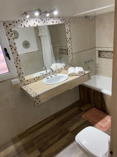 W łazience znajduje się umywalka, lustro i wanna. w obiekcie LAJUA aeropuerto Ezeiza II w mieście Barrio Esteban Echeverría