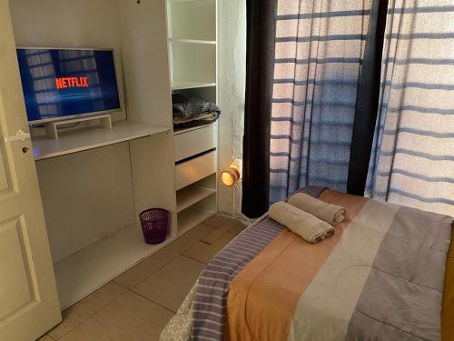 1 dormitorio con 1 cama y TV en una habitación en LAJUA aeropuerto Ezeiza II en Barrio Esteban Echeverría