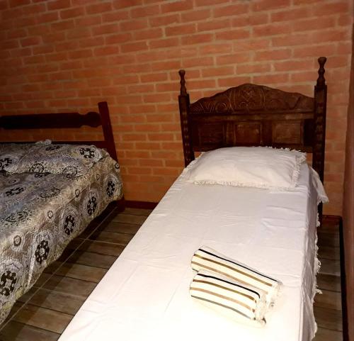 ein Schlafzimmer mit zwei Betten mit Handtüchern darauf in der Unterkunft Chalé mirante da Serra rua E nova ibitipoca Lima Duarte MG in Ibitipoca