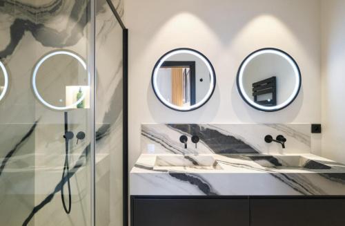 une salle de bain avec deux lavabos et deux miroirs dans l'établissement Cannes Croisette Port Canto Les Dunes, à Cannes