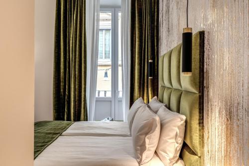a bedroom with a bed with a headboard and a window at Goldoni 47 in Rome