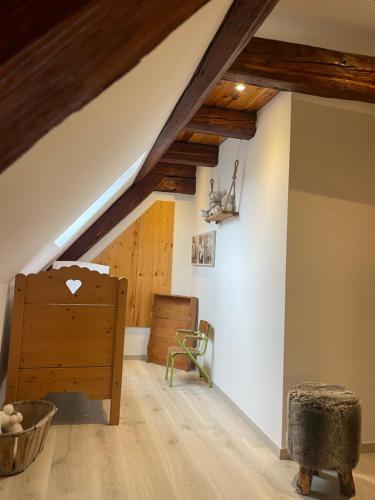 une chambre mansardée avec des poutres en bois et une commode en bois dans l'établissement Le cœur d'Alsace 2 à 6 pers à 5 min de Ribeauvillé, à Guémar