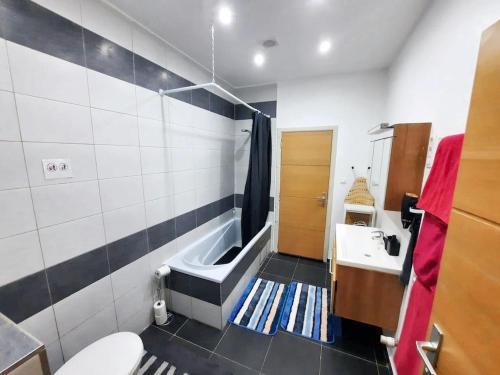 La salle de bains est pourvue d'une baignoire, d'un lavabo et de toilettes. dans l'établissement One bedroom apartement with wifi at Molenbeek Saint Jean, à Bruxelles