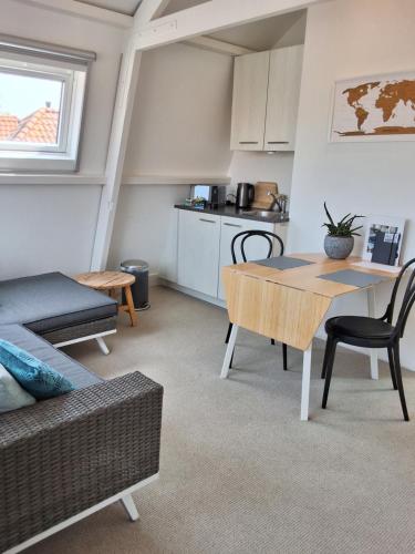 Appartement Havenzicht في إنكهاوزن: غرفة معيشة مع طاولة وأريكة