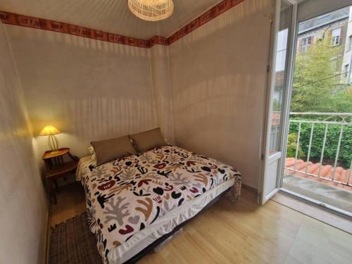 a bedroom with a bed and a large window at Maison au cœur de la cité in Foix