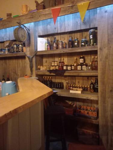 a bar with a counter and shelves with bottles at Mountain Log Cabin O Garrano in Cabeceiras de Basto