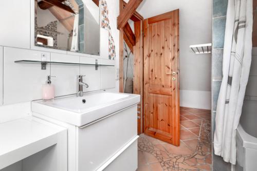 een badkamer met een wastafel en een houten deur bij Pension Beermann in Wedemark