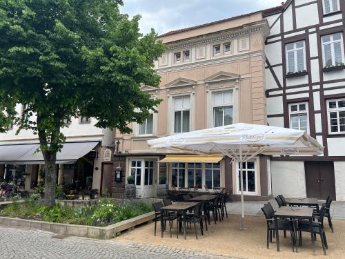 a tables and chairs with an umbrella in front of a building at Hotel Brauhaus Bückeburg in Bückeburg