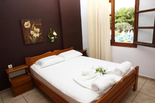 una camera da letto con un letto e asciugamani bianchi di Nikos Apartments a Stalida