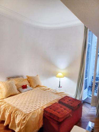 ein Schlafzimmer mit einem großen Bett mit einer roten Ottomane in der Unterkunft Appartement d'une chambre avec wifi a ParisEL in Paris