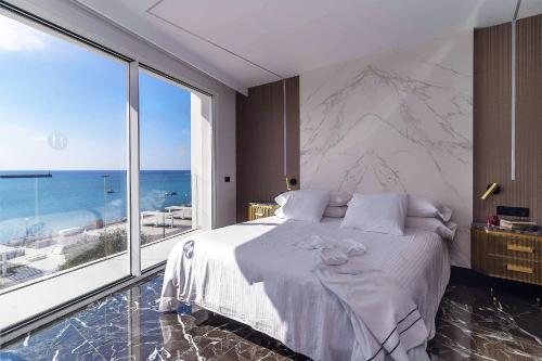 a bedroom with a large bed and a large window at Blue Marina Suites - Boutique Apartments in Arrecife