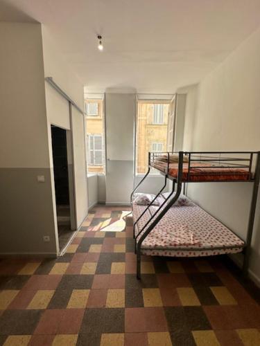 Zimmer mit Etagenbett und kariertem Boden in der Unterkunft Hotel SHEFFA in Marseille