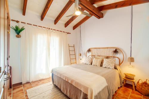 1 dormitorio con cama y ventana grande en Ca Nura - Dúplex con piscina y a pasitos del mar en Son Xoriguer
