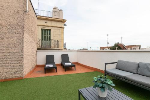 un patio con 2 sillas y un sofá en el techo en Chic and Modern Apartments in Gracia, en Barcelona