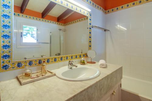y baño con lavabo y espejo. en Ca Nura - Dúplex con piscina y a pasitos del mar en Son Xoriguer