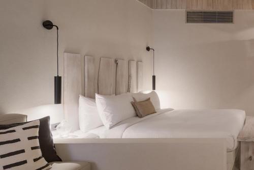 1 cama blanca con almohadas blancas en una habitación en Marmarica Boutique Cabana's - Ras El Hekma - North Coast, en Marsa Matruh